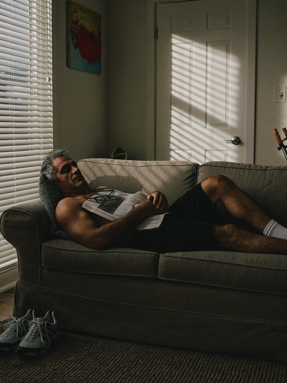 A fit man asleep on the couch at 3 p.m.